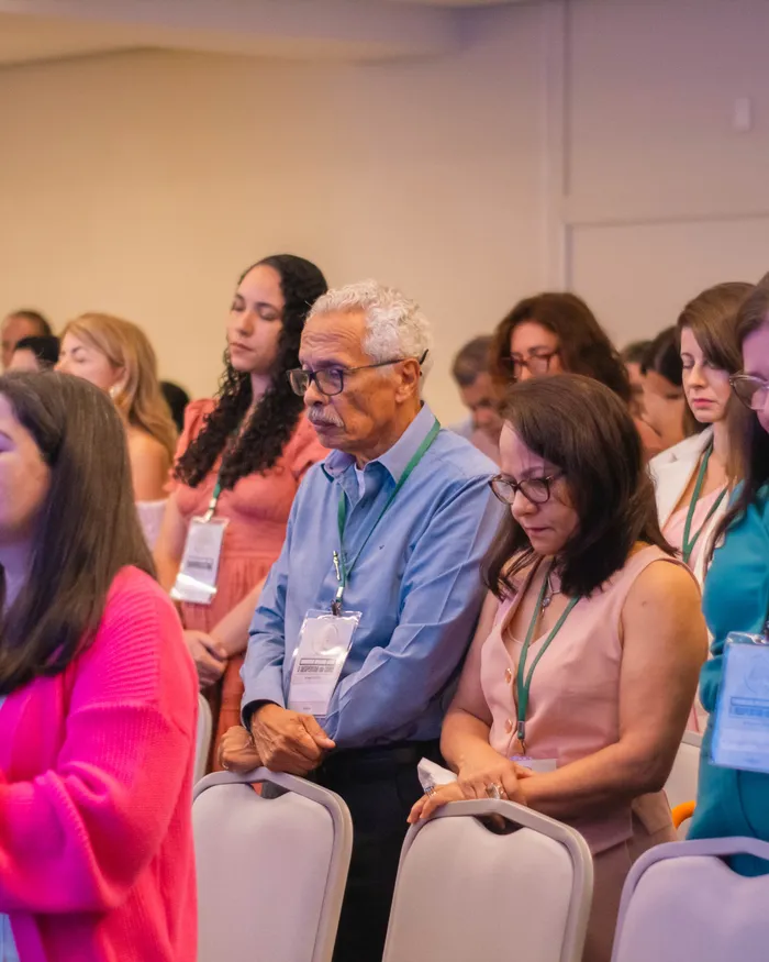 Plateia sorridente acompanhando as palestras do congresso